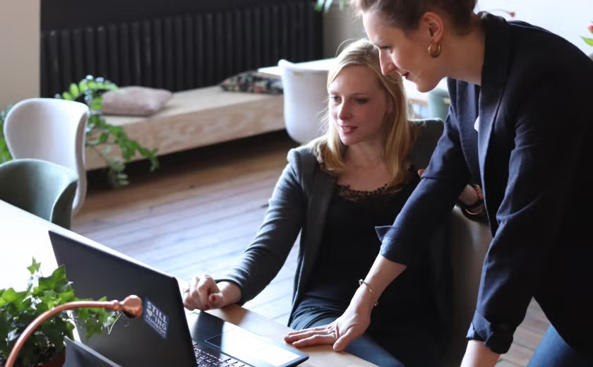 two women colleagues workint at a laptop