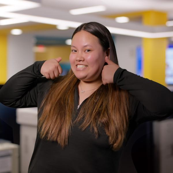 Student smiling and holding her thumbs up
